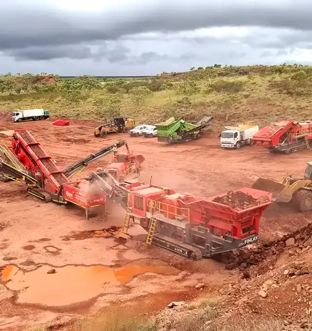 mining equipment australia. Remote mining site with mobile crushing equipment, loader, grader and trucks.